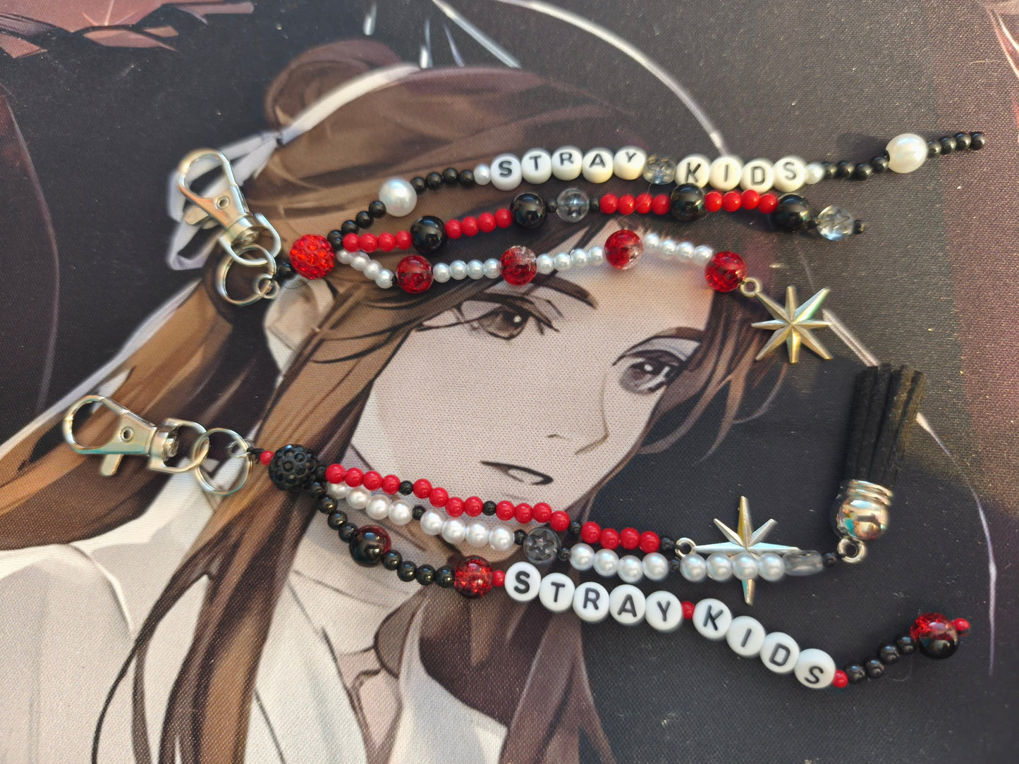 Handgemachter K-Pop Schlüsselanhänger inspiriert von The Rose und Stray Kids mit silbernen Charms.